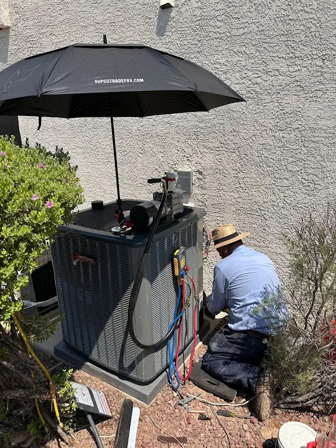HVAC technician performing outdoor AC maintenance in Woodmoor