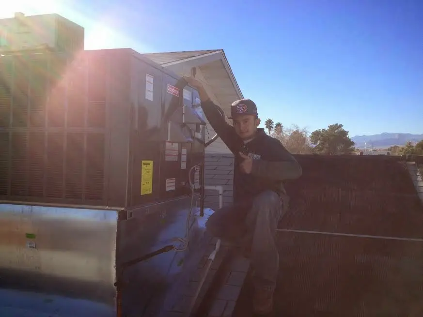 HVAC technician performing Boiler Repair on a rooftop unit in Woodmoor